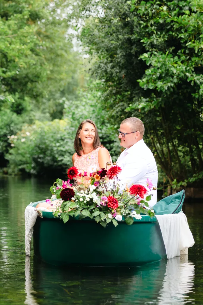couple amoureux, séance photo romantique, barque fleurie, hortillonnages Amiens, romance au fil de l’eau, photographe couple, Hauts-de-France, expérience insolite, balade en barque traditionnelle, moment complice, fleurs colorées, photographie naturelle, séance engagement, photographe Amiens, expérience poétique, souvenir romantique, nature verdoyante, barque décorée de fleurs, authenticité, instant de bonheur